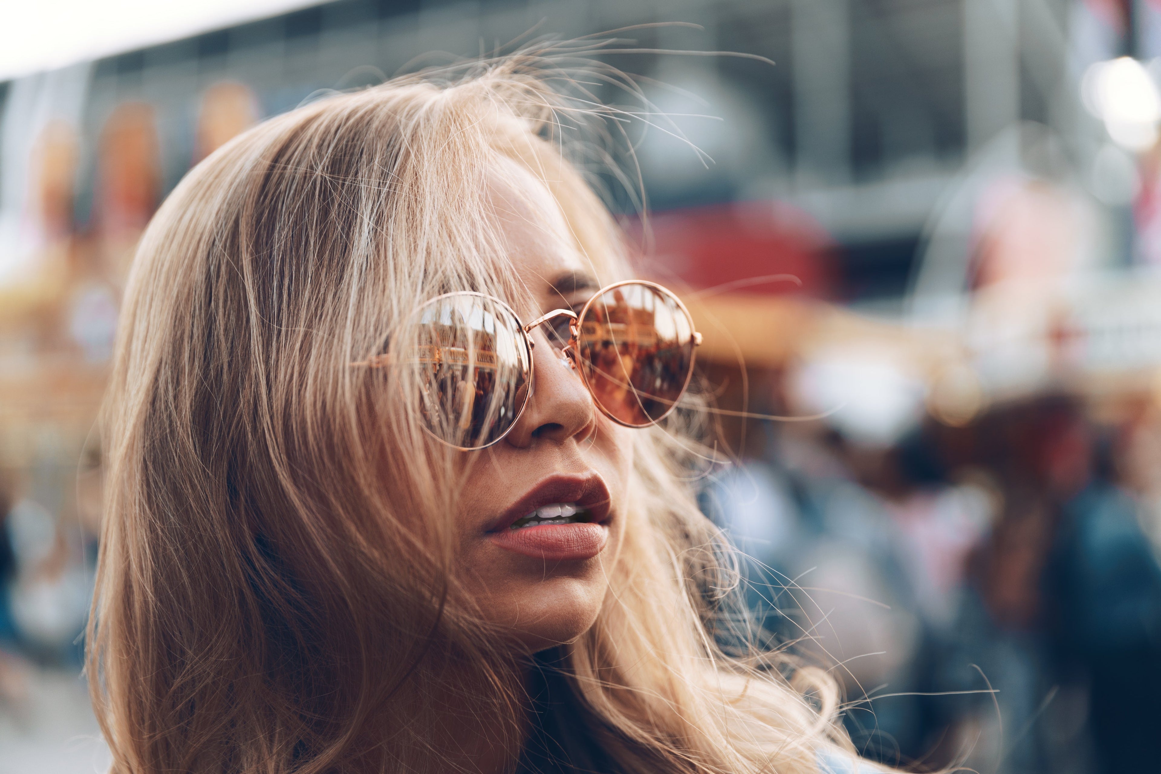 Woman wearing sunglasses with a blurred urban background