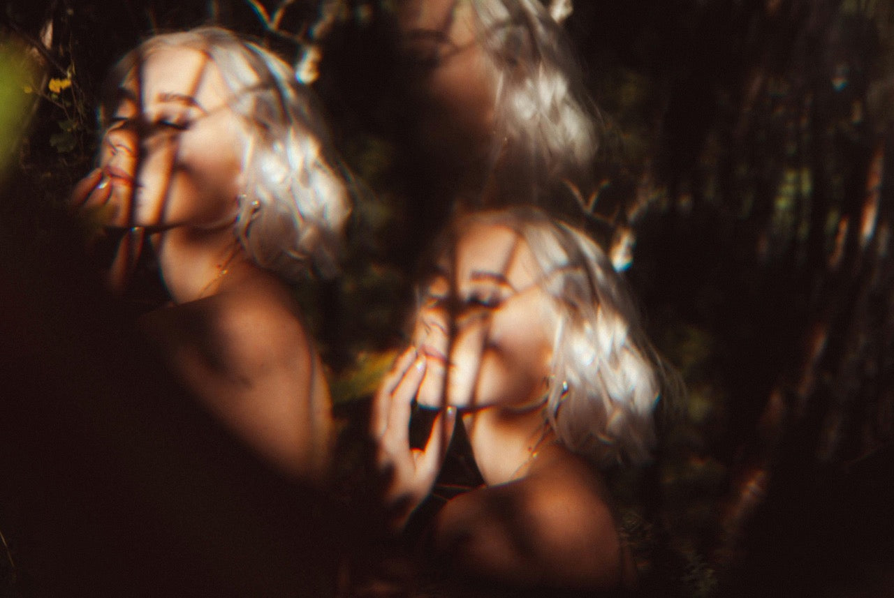 Blurred image of a person with long hair in a natural setting